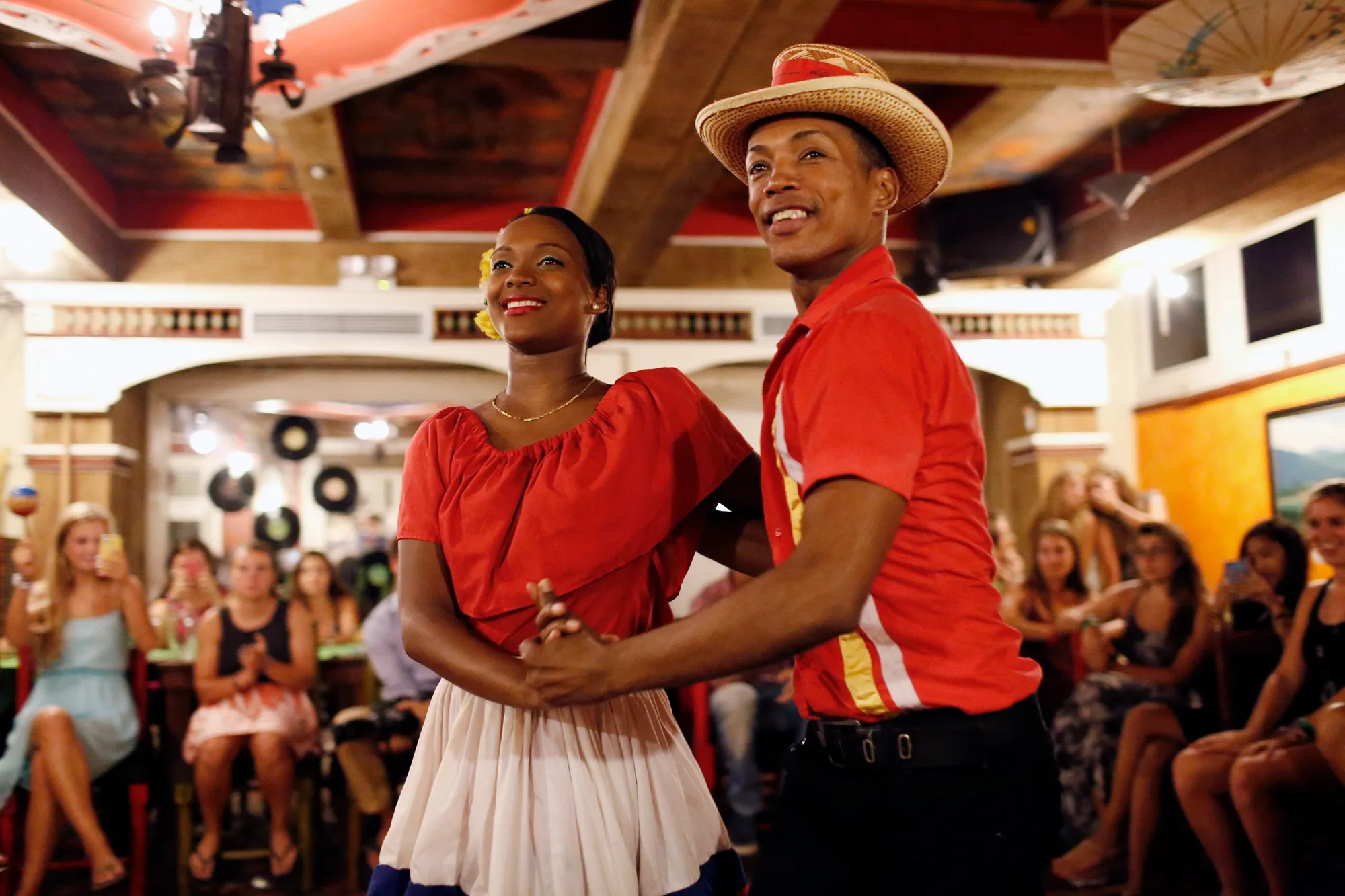 A couple dancing in red outfits during a celebration in the Dominican Republic