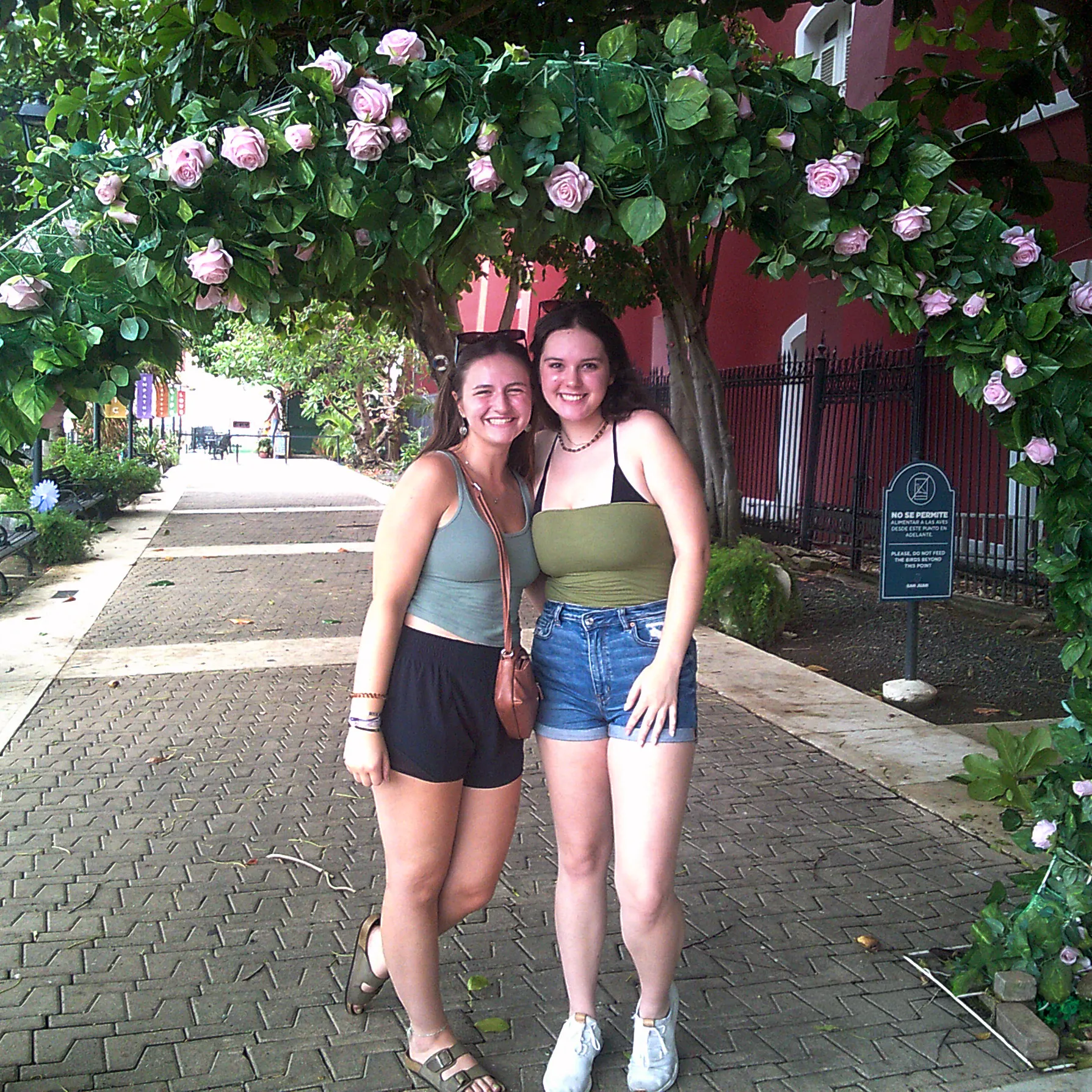 Two travelers posing together beside a historic marker on a street in Puerto Rico
