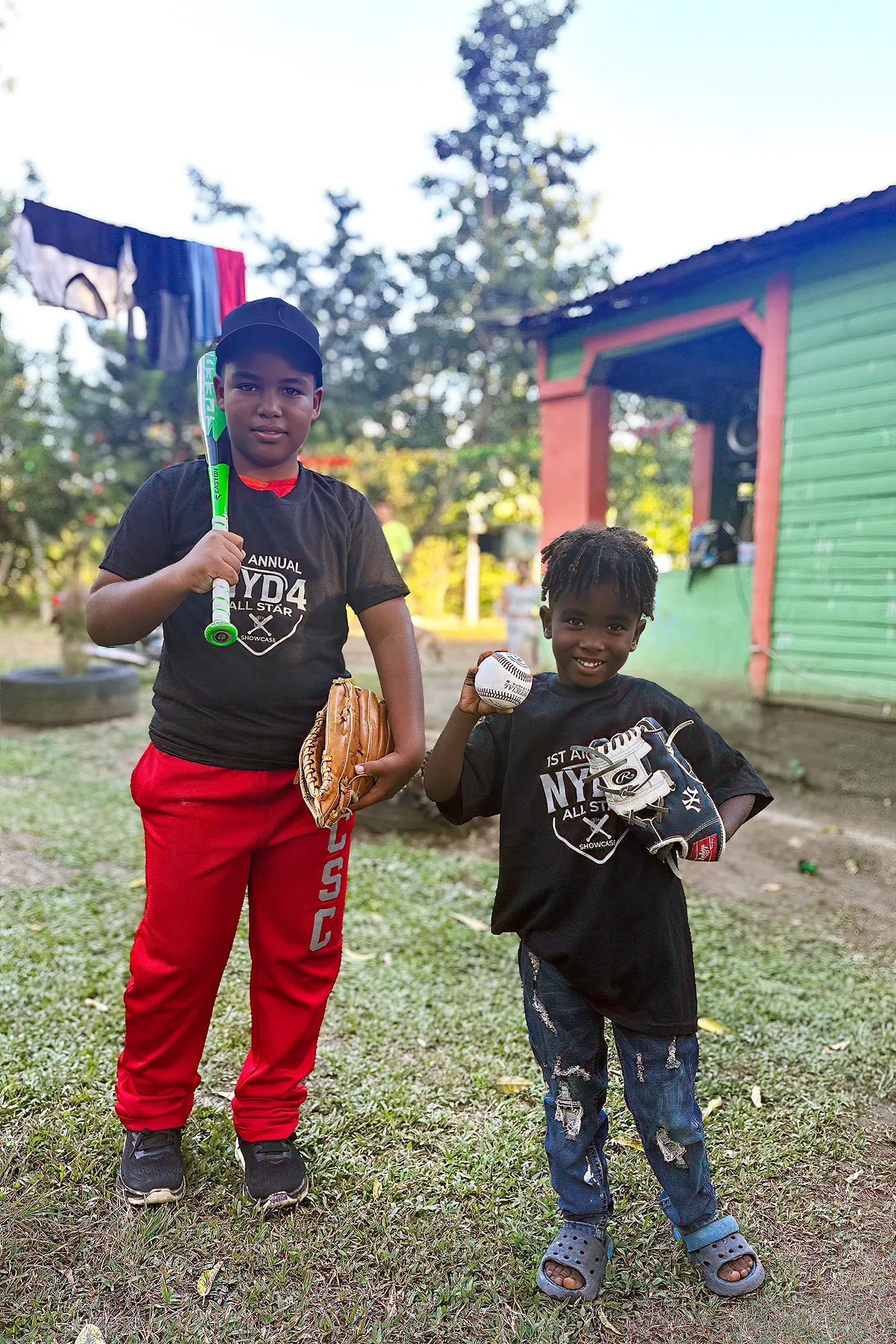 A smiling child holding a baseball and glove in the Dominican Republic