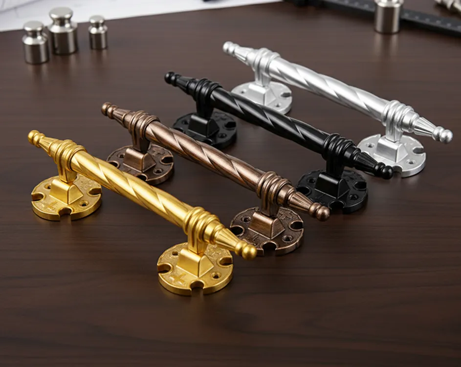 Četiri ukrasne ručke za nameštaj u zlatnoj, bronzanoj, crnoj i srebrnoj boji na tamnom drvenom stolu.