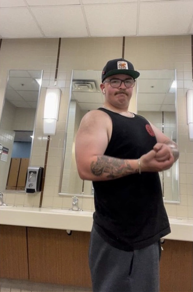 CUT STACK I – customer progress photo flexing in a gym locker room