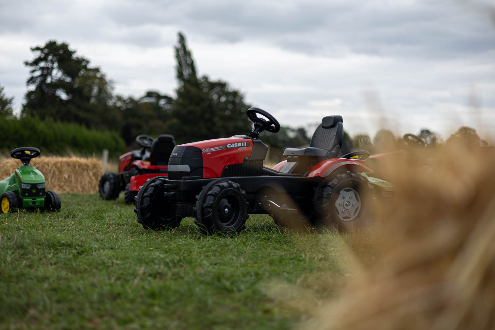 Children's pedal tractors on the grass at Overstone Grange Farm