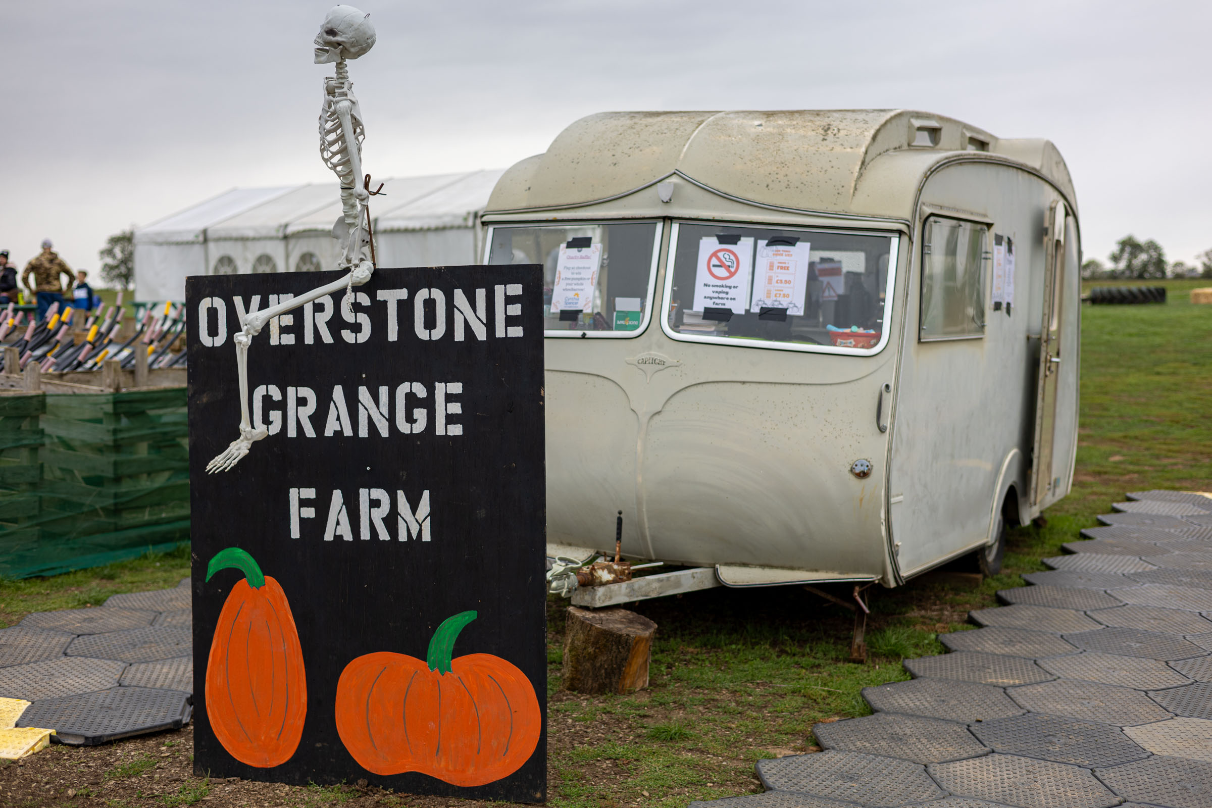 Overstone Grange Farm sign and vintage caravan at the entrance
