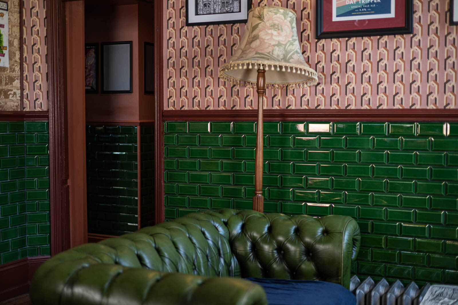Green leather Chesterfield sofa and tiled wall at The Garibaldi Hotel