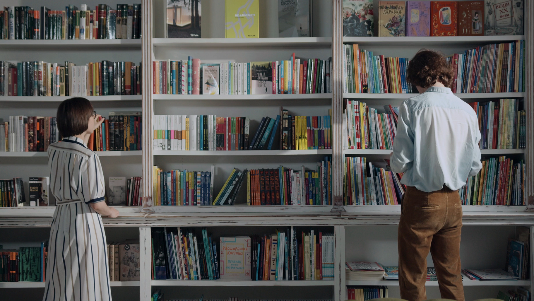 Deux personnes consultent des ouvrages dans une bibliothèque