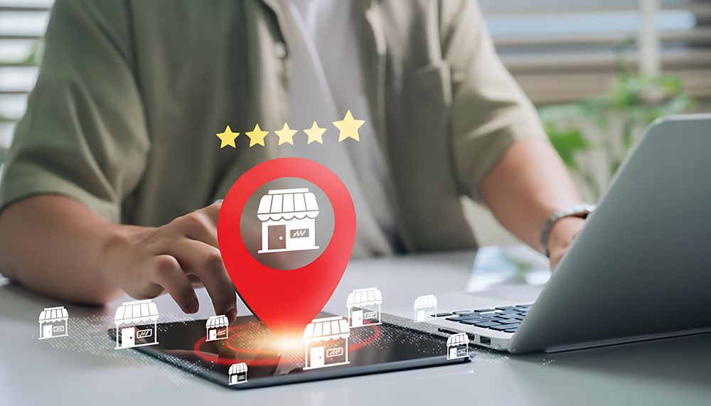 Person working on a website with a local map pin and storefront icons.