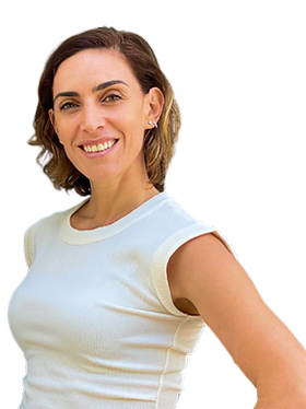 Smiling woman with short brown hair wearing a white sleeveless top, standing with her hand on her hip.