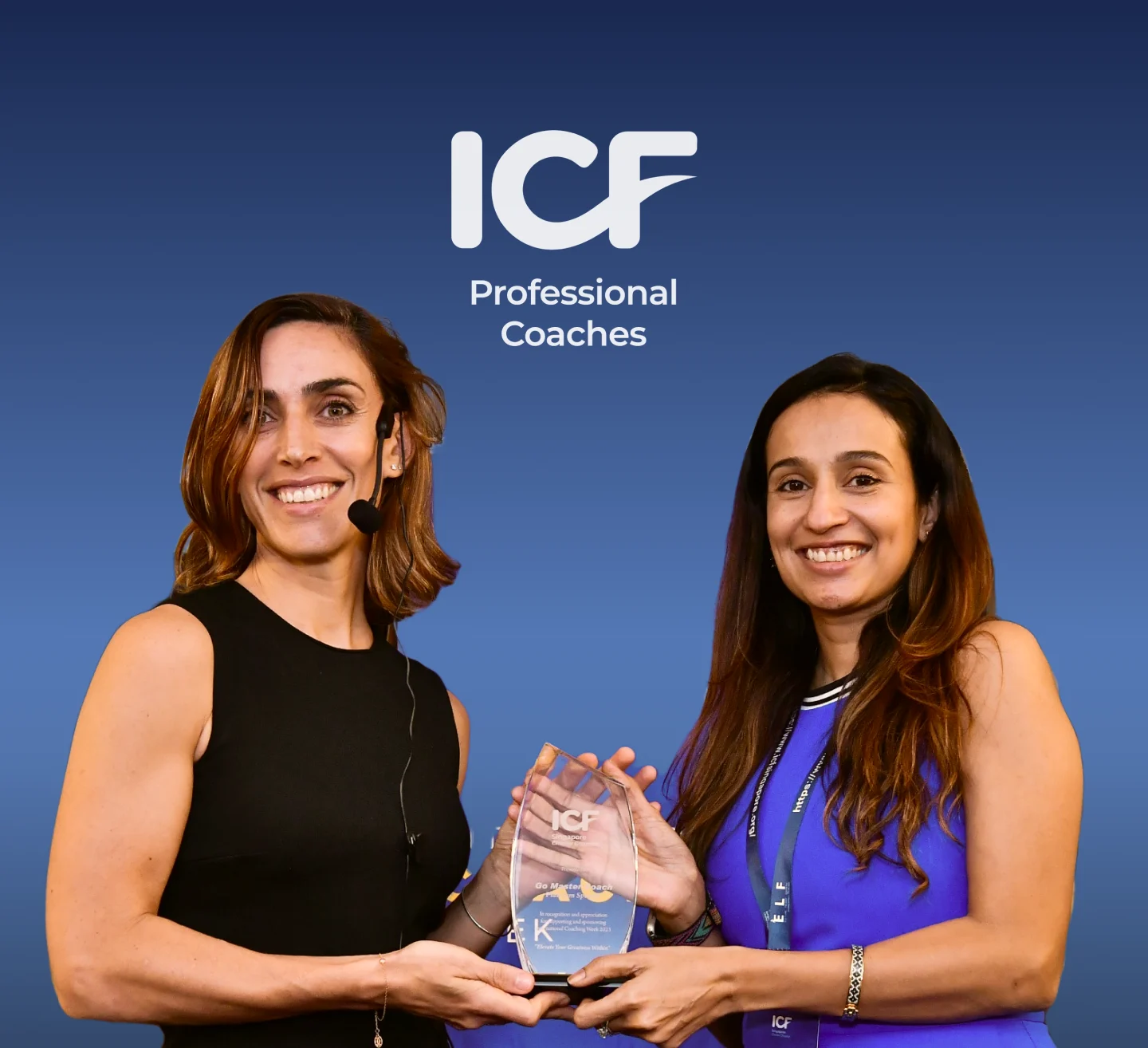 Two smiling women holding an ICF award plaque, with 'ICF Professional Coaches' text above them on a blue gradient background.
