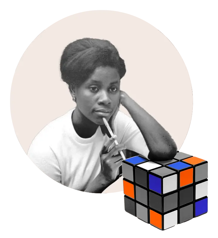 Thoughtful woman holding a pen near her lips with an unsolved Rubik's cube in front of her.