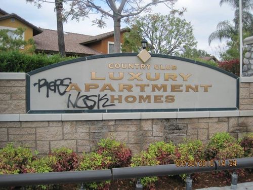 Vandalized entrance sign for luxury country club apartment homes