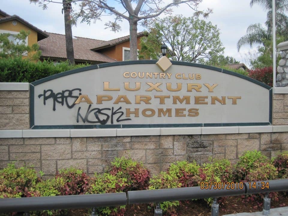 Vandalized entrance sign for luxury country club apartment homes