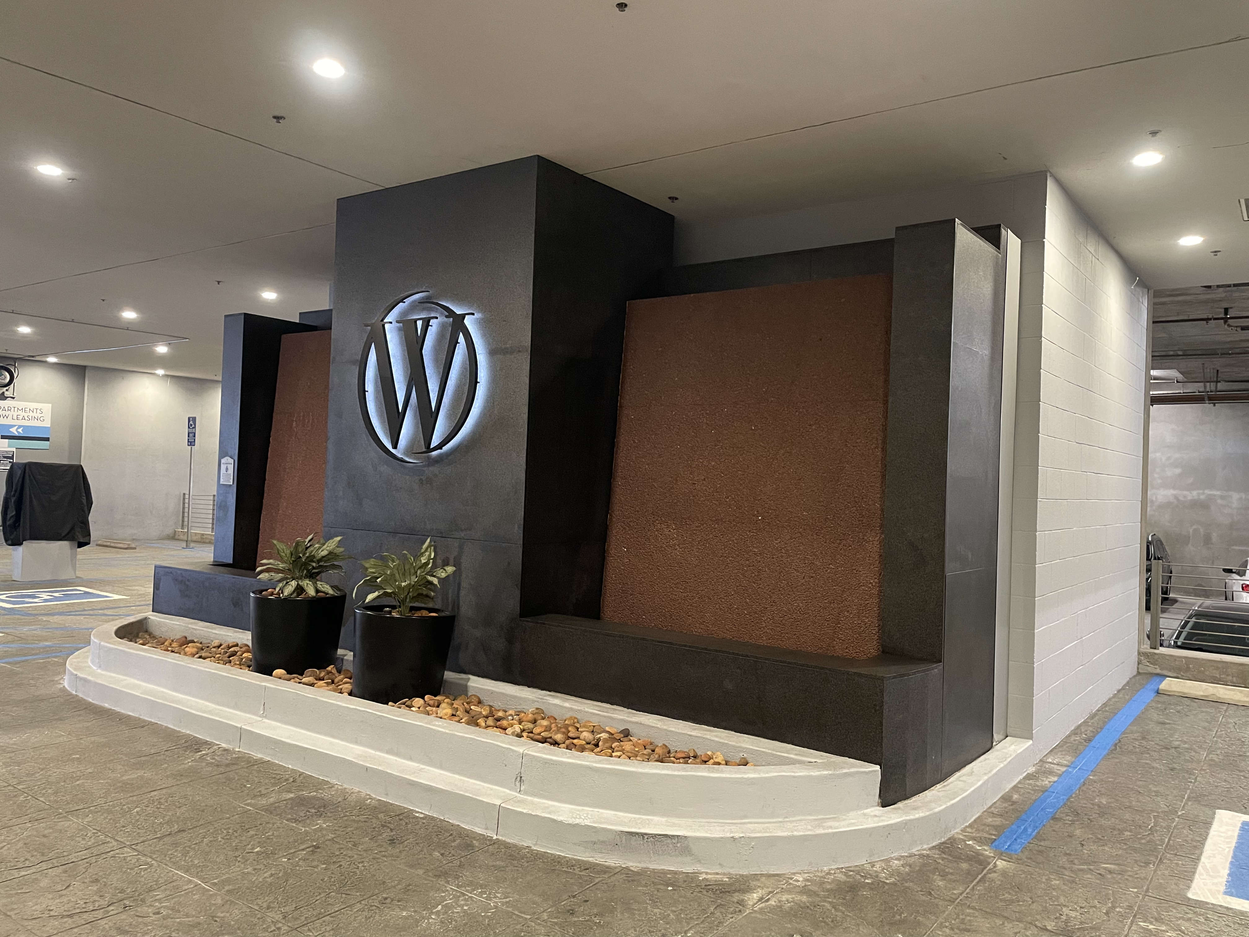 Modern lobby with W logo, plants, and decorative stone backdrop