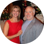 Smiling middle-aged woman with short brown hair wearing a colorful patterned top.