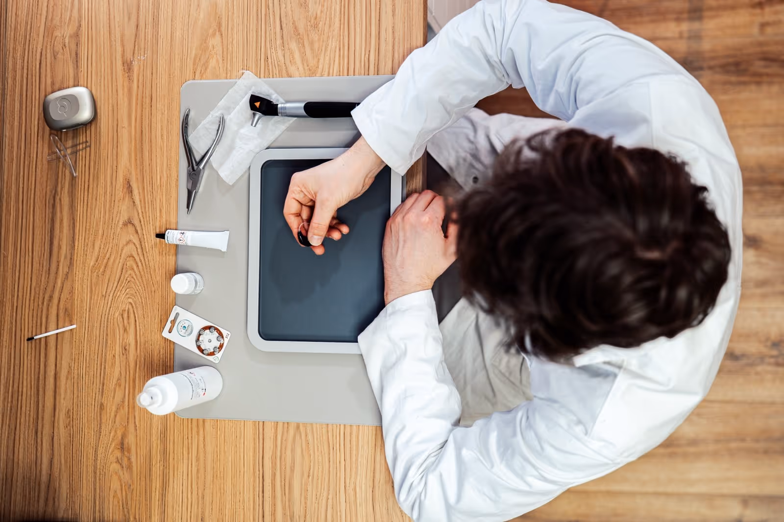 Junger Mann in blauem Pullover und beiger Hose, der auf einem gepflasterten Platz vor einem gelben historischen Gebäude spaziert.