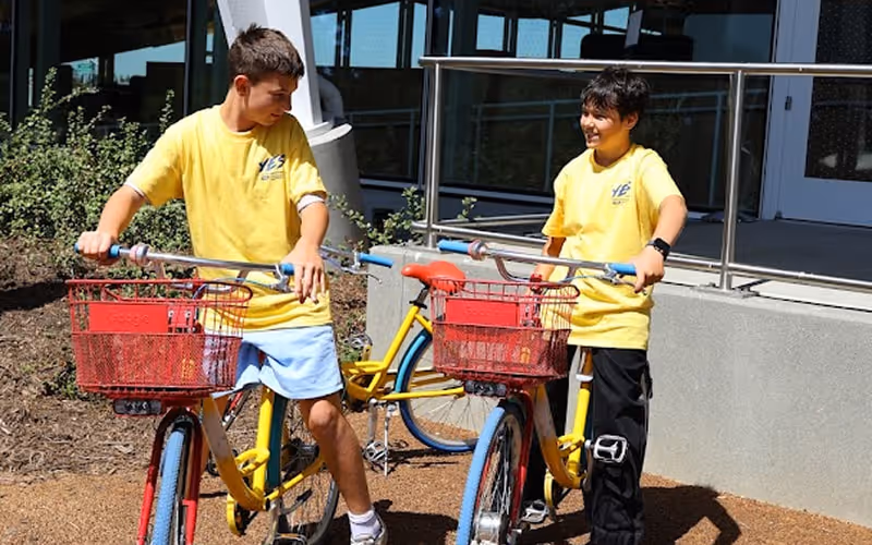Two boys are riding bikes on the sun.