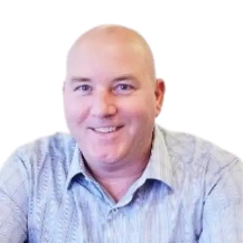 Smiling bald man wearing a light blue patterned button-up shirt.