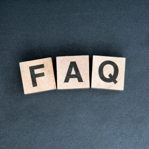 Wooden blocks with the letters F, A, and Q on a dark textured surface.