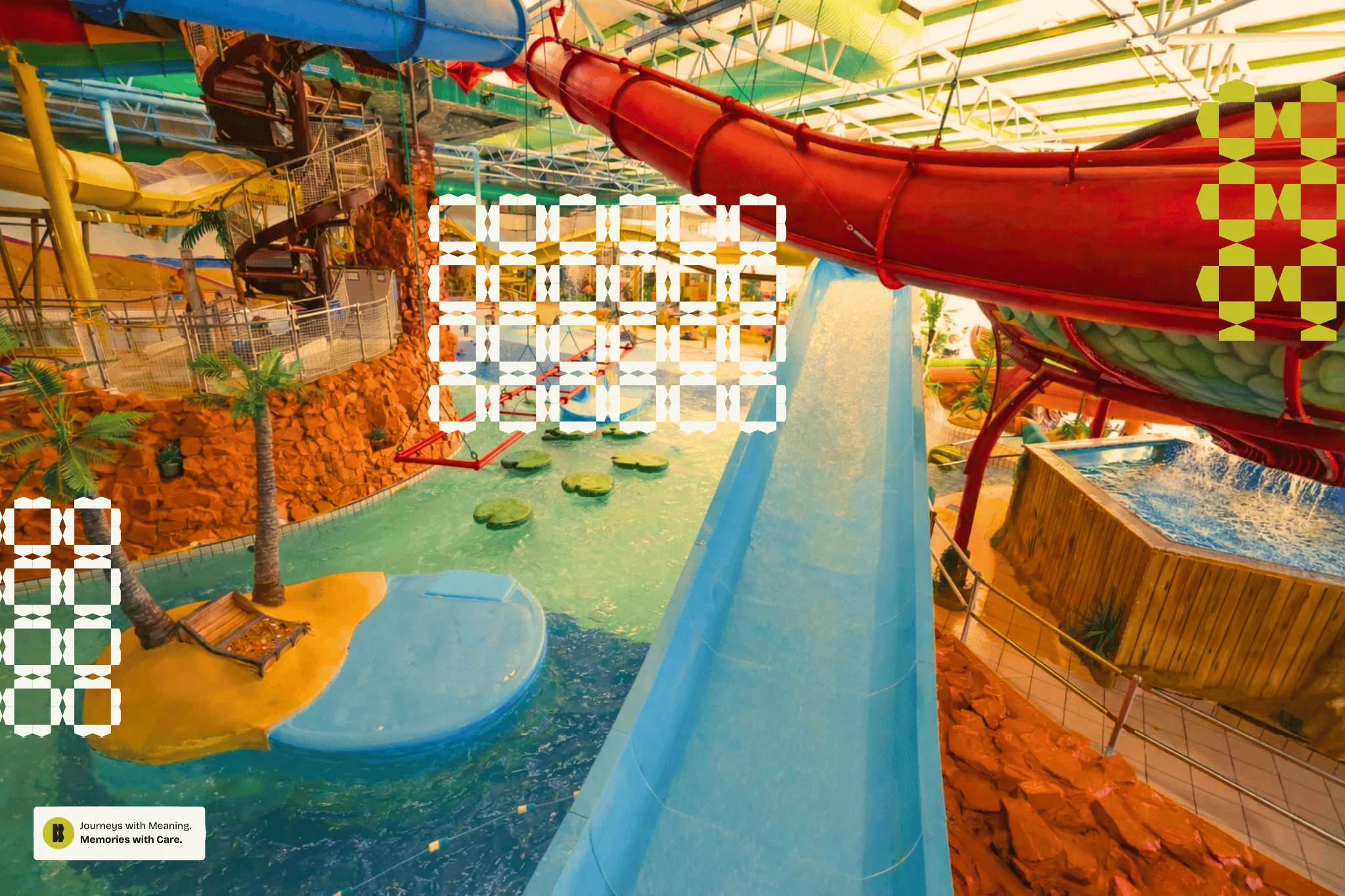Indoor water park with various colorful water slides, a pool with stepping stones, palm trees, and a splash pool.