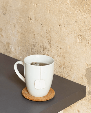 A woman with short blonde hair smiles and leans toward a seated woman with dark hair wearing a headset, who is typing on a keyboard.