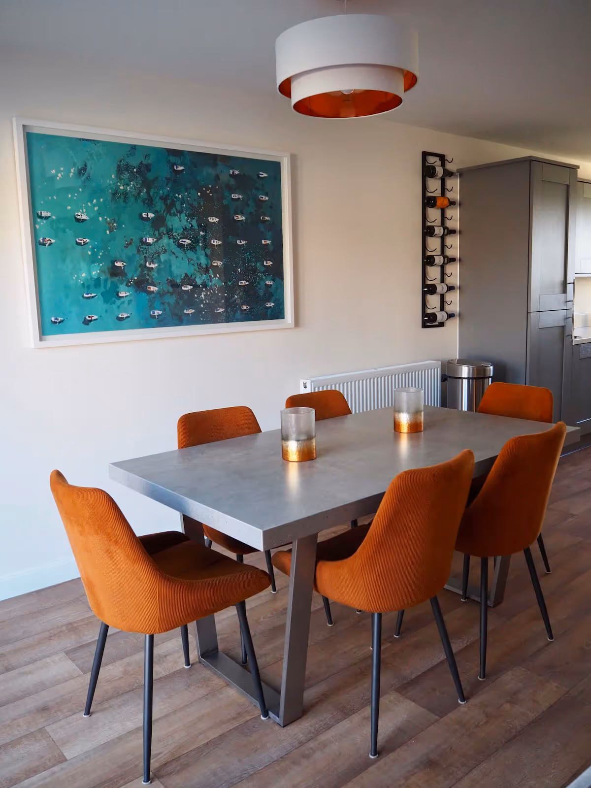 Front entrance of a modern two-story white house with a dark gray door, porch light, and small concrete steps leading up to the door.