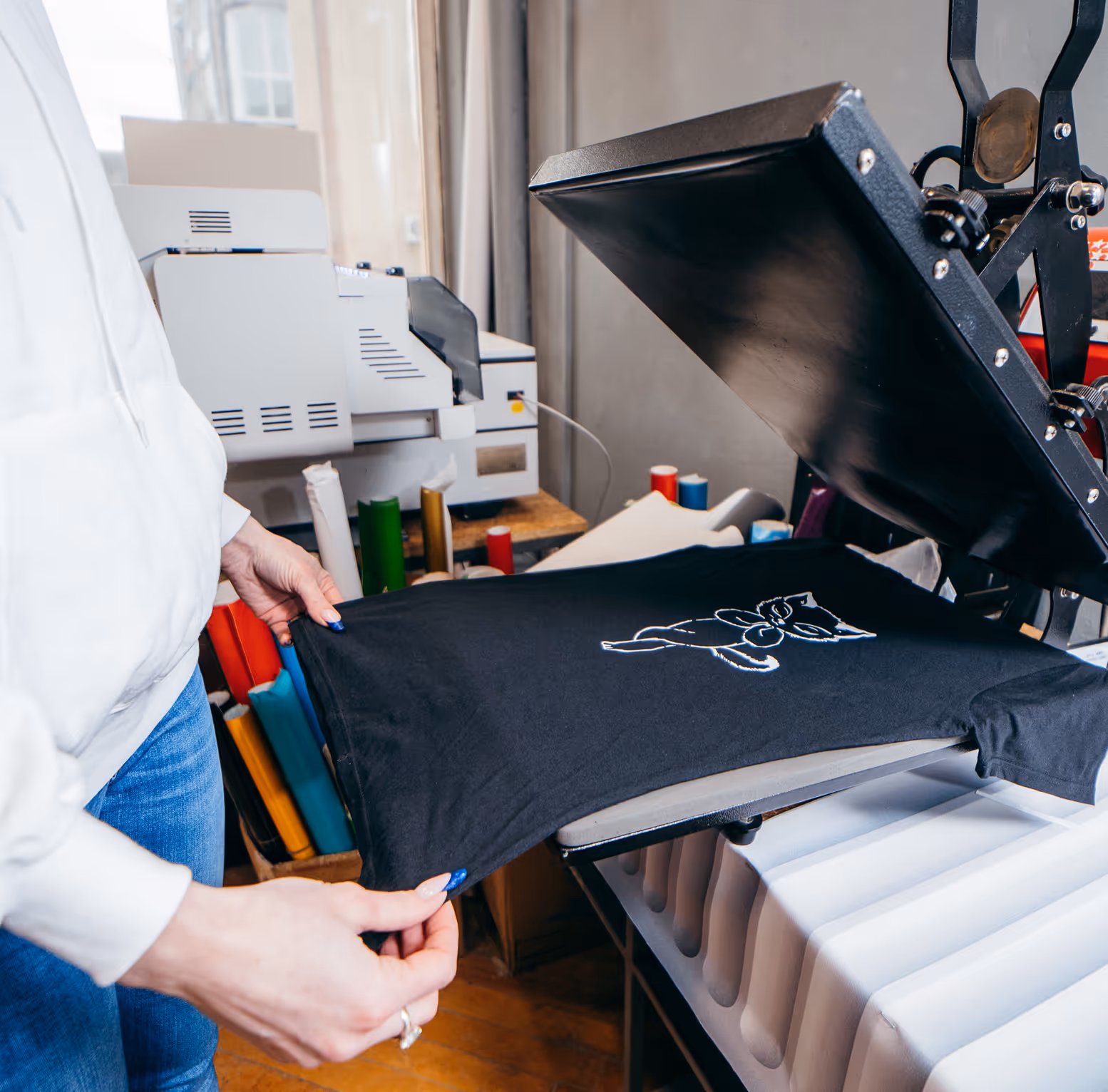 Heat press machine printing a custom design onto a t-shirt.
