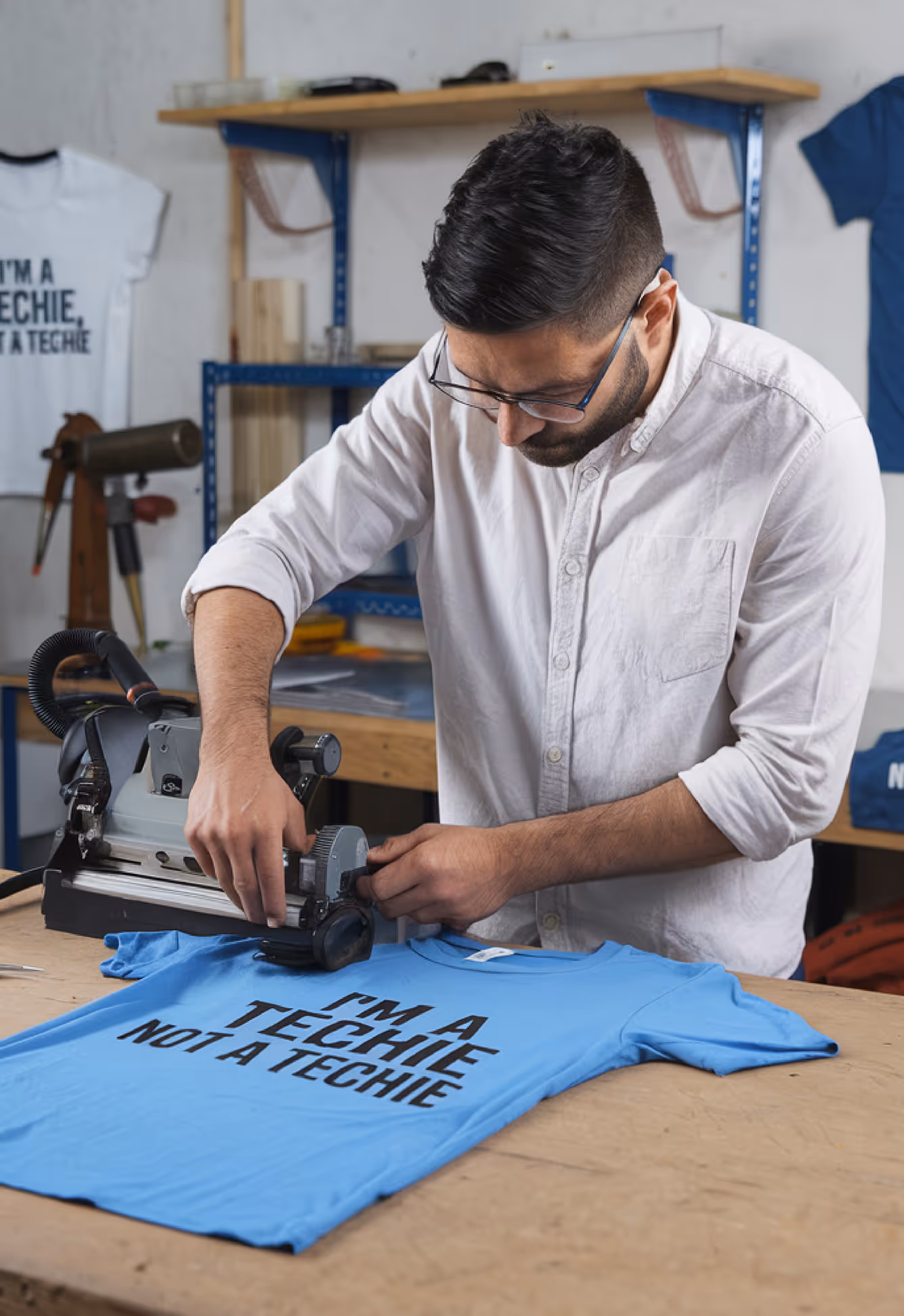 Worker screen printing custom apparel in a professional production environment.