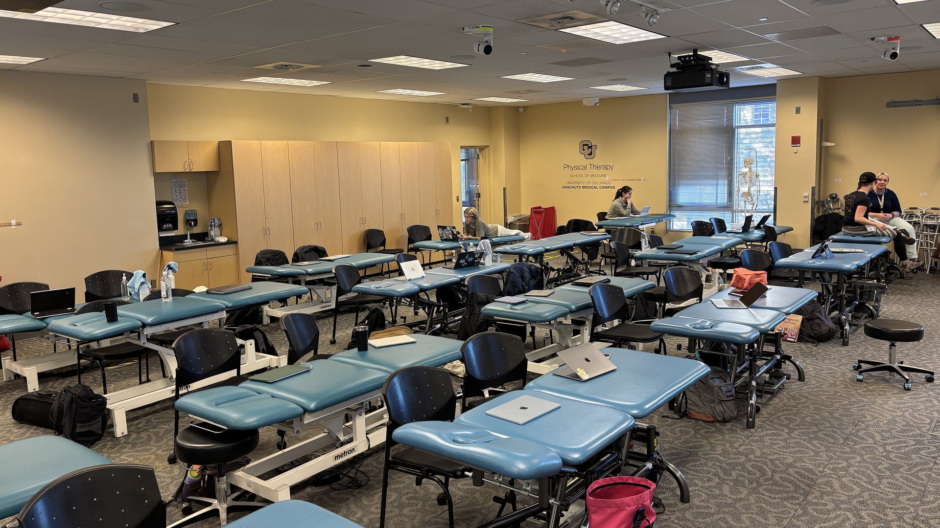 Salle de traitement d'un cabinet de kinésithérapie, tables de rééducation alignées