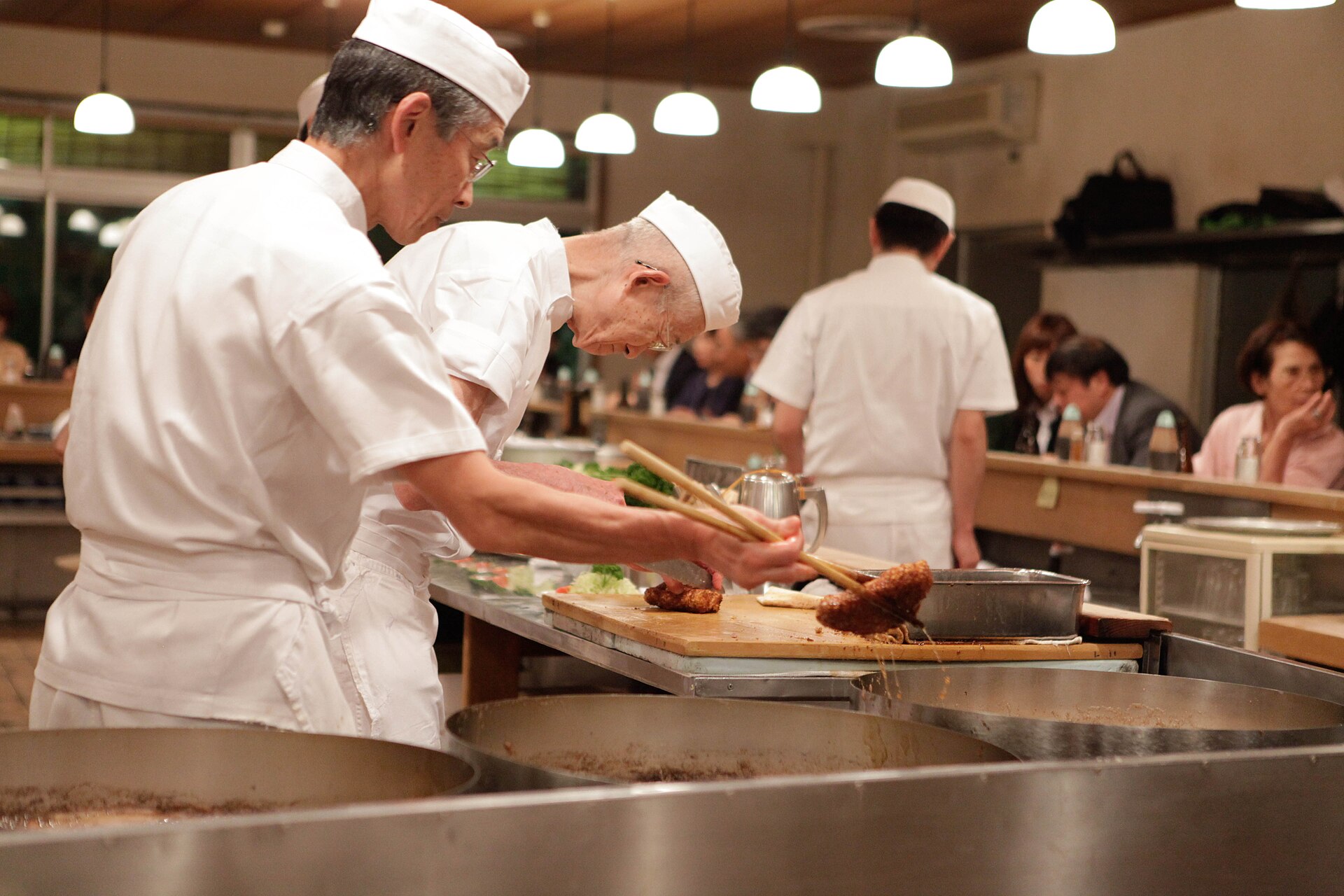Cuisiniers au travail dans un restaurant, un commerce exploité en nom propre