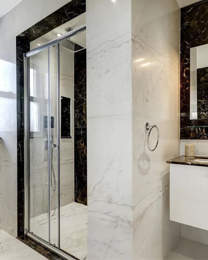 Marble & stone · Vanity and shower with contrasting stone borders