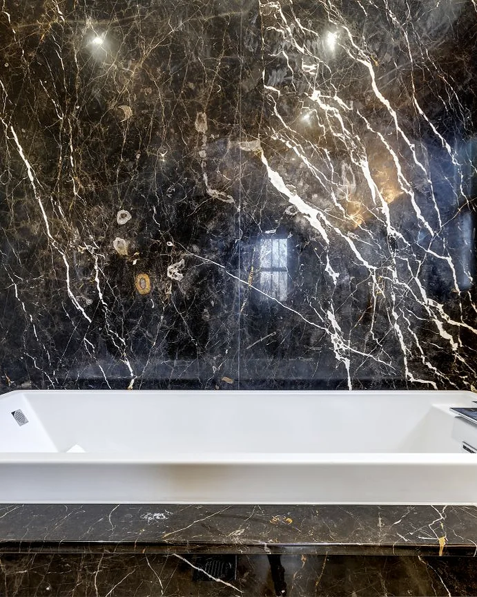 Marble & stone · Dark veined stone around a bath