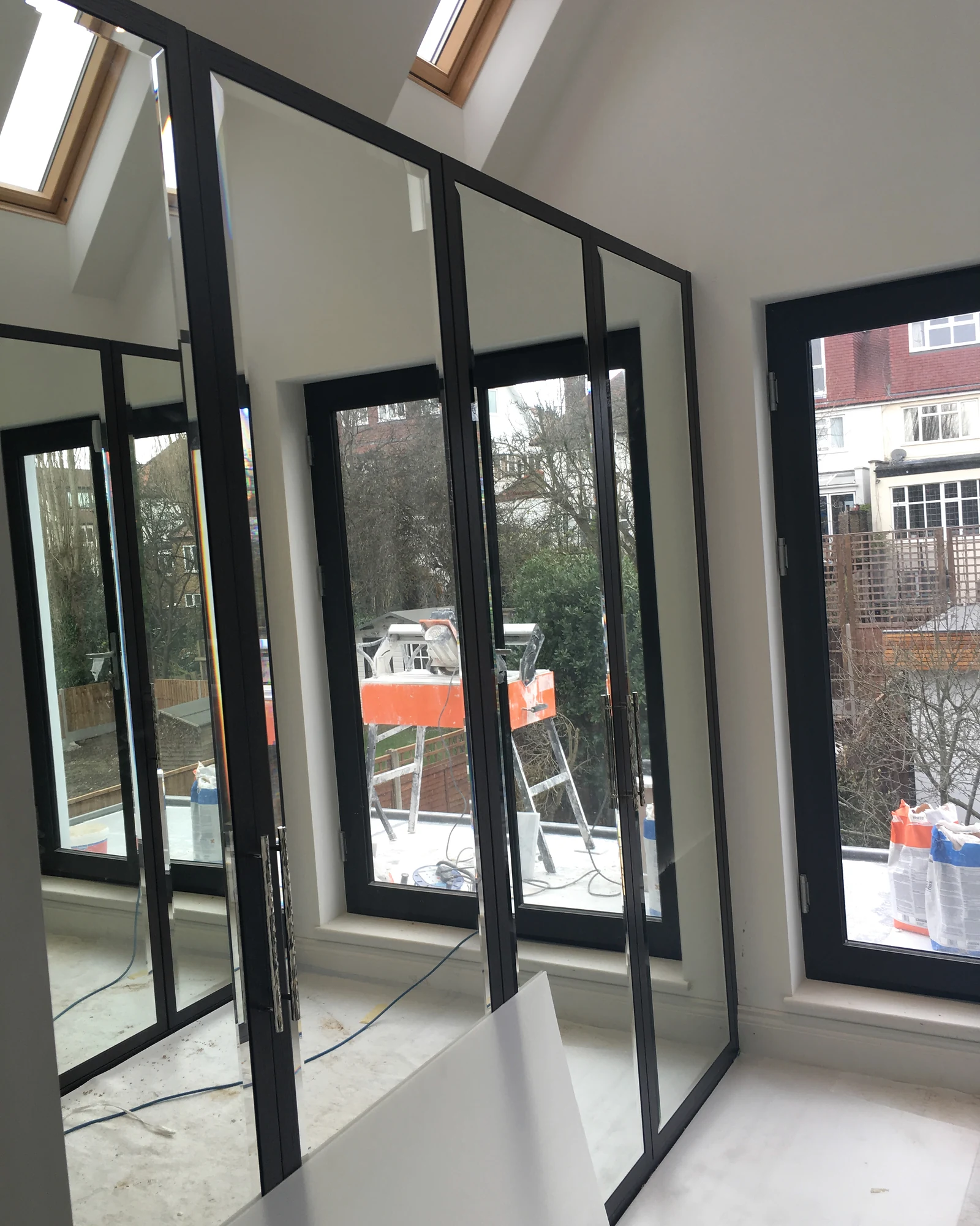 Framed mirrored doors beneath a rooflight