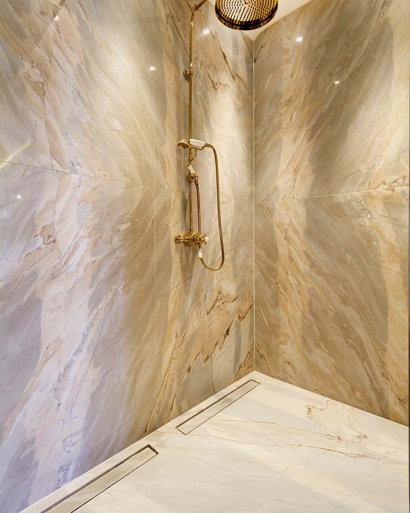Veined stone surfaces meeting within a shower enclosure
