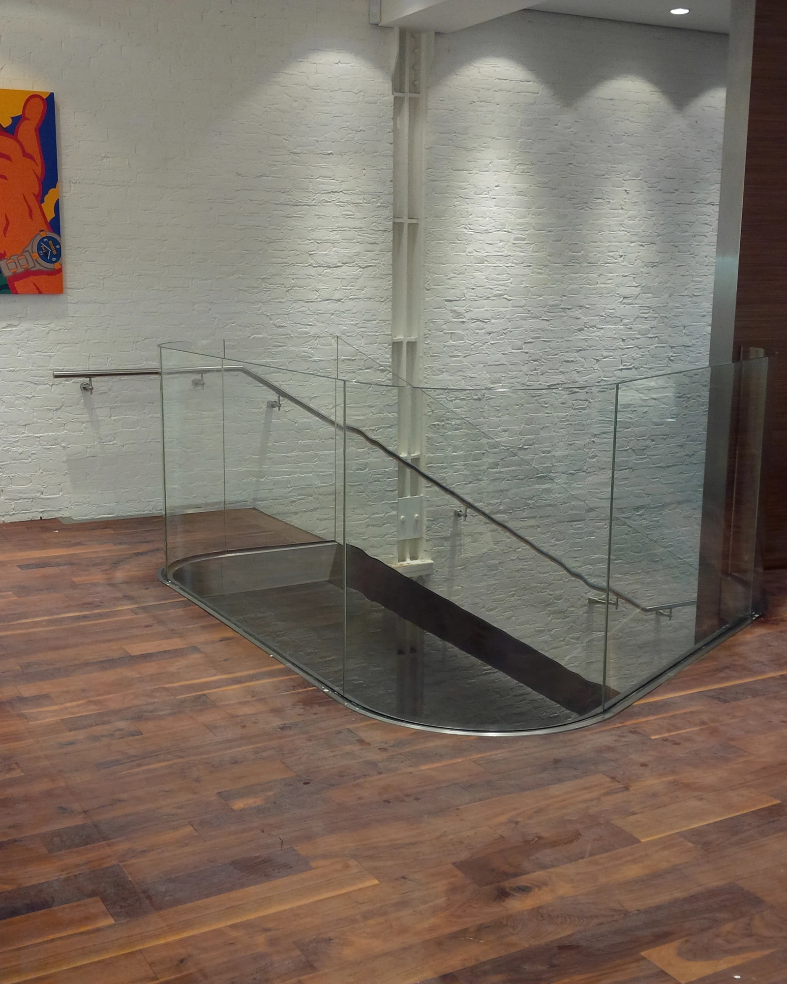 Curved glass balustrade at a timber stair opening