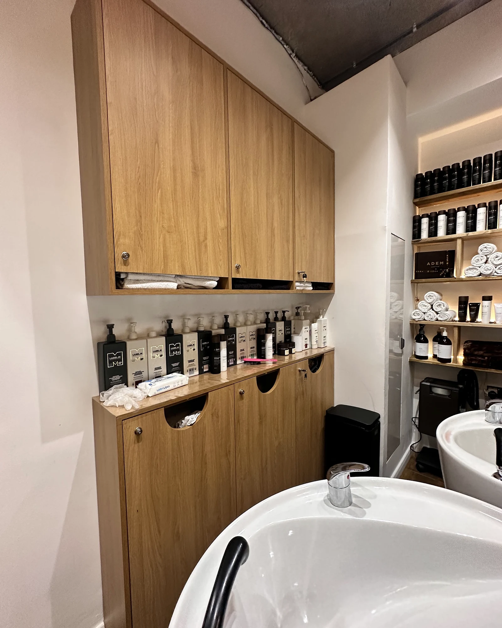 Fitted timber cupboards and storage beside the wash stations