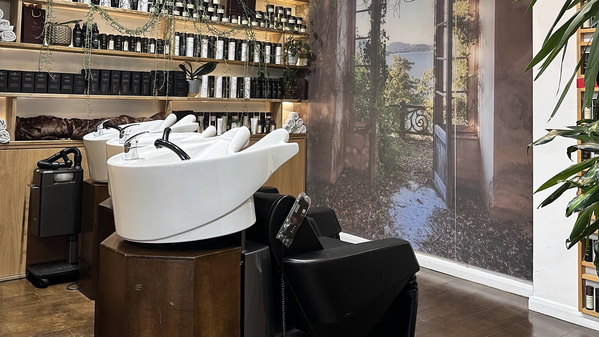Wash stations, illuminated shelving and wall mural at Adem hair salon