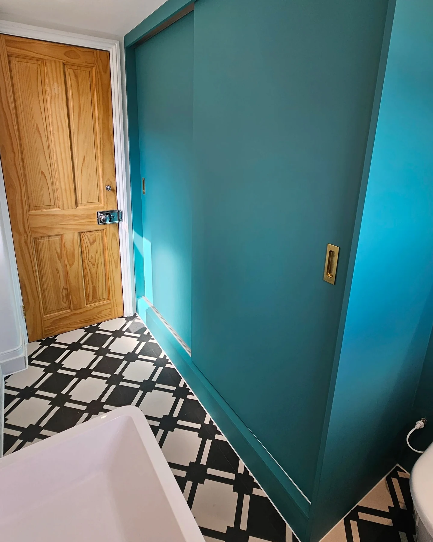 Cloakroom with painted sliding doors and patterned flooring