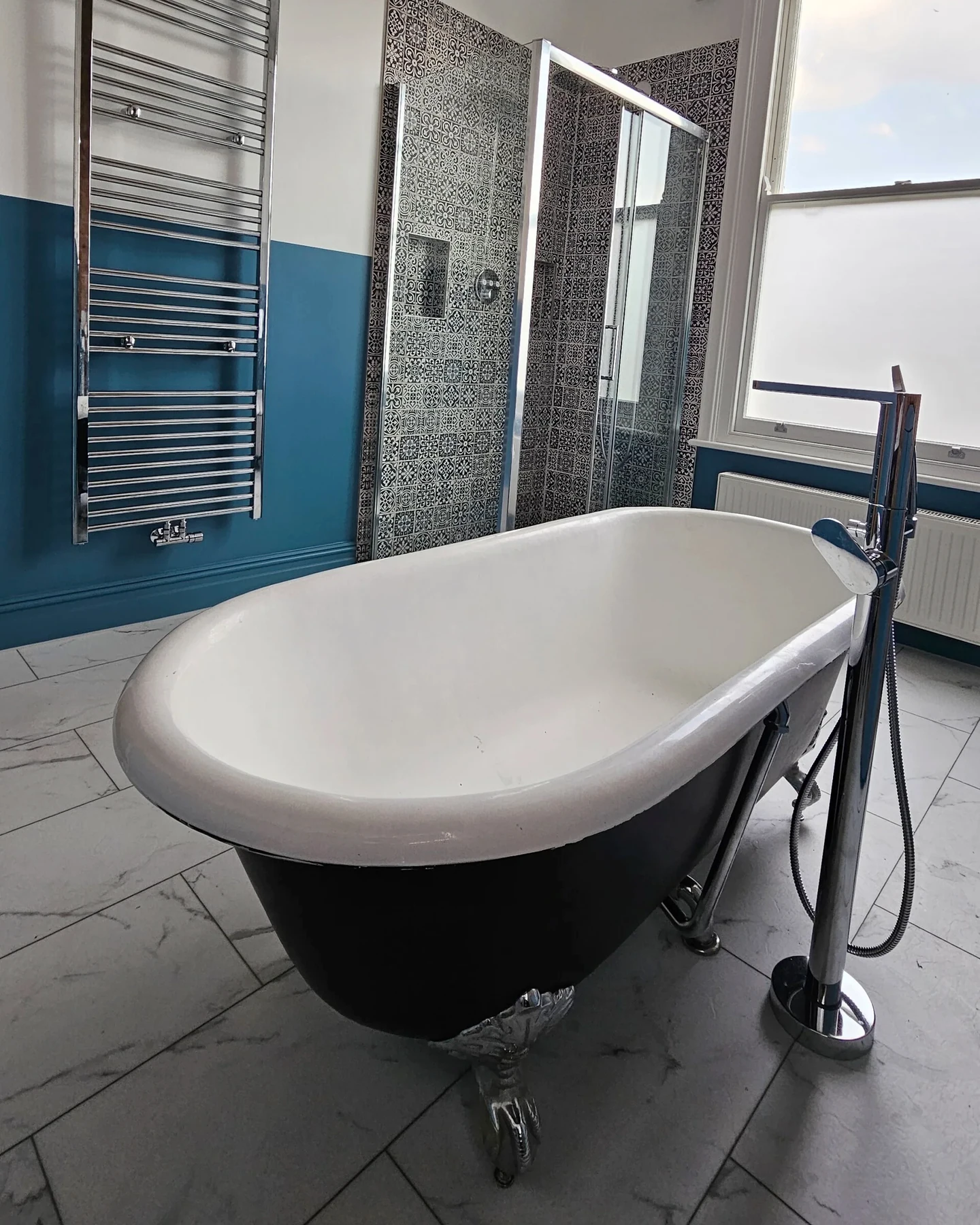 Freestanding bath beneath a sash window in the Highbury house