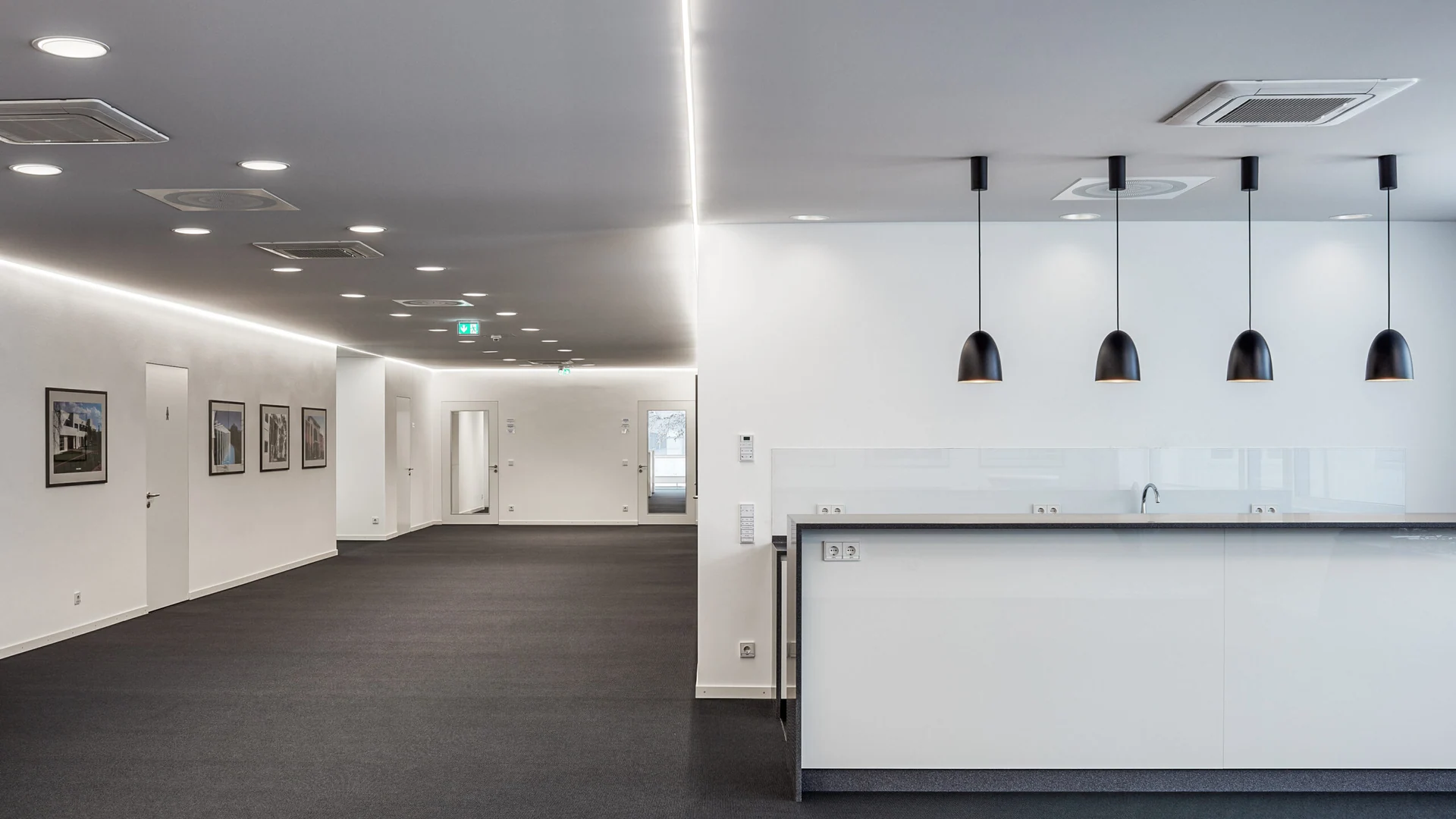 White DESCOR textile ceiling with a continuous line of indirect light and black pendant lights, a PONGS reference in Speyer