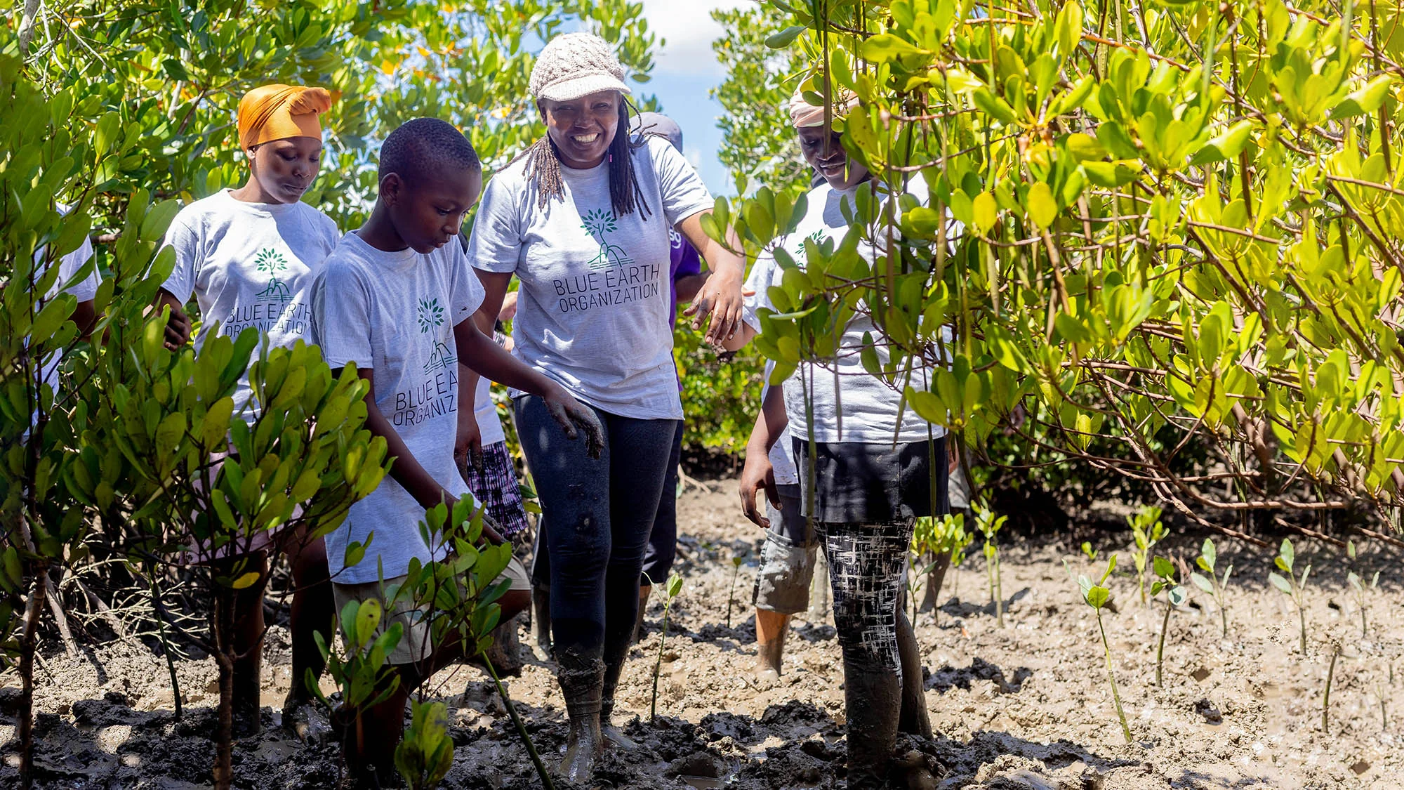 People surrounded by mangroves, a smiling woman walking towards the camera