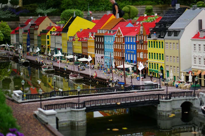 Miniature cityscape built from LEGO bricks at a LEGOLAND attraction, with colourful buildings reflected in water.