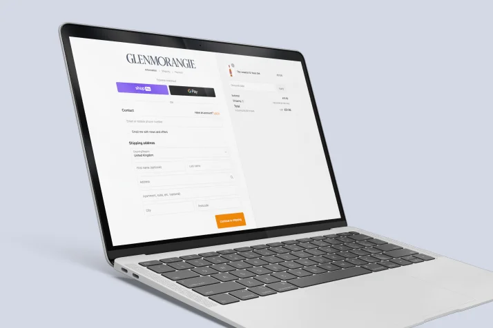 Laptop displaying Glenmorangie online checkout page with payment options and shipping address form.