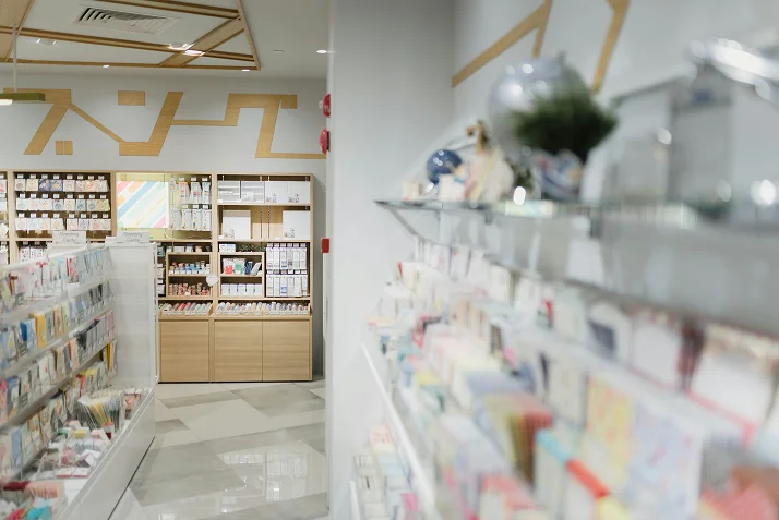 Interior of a modern stationery store with shelves filled with colorful stationery items and crafts.