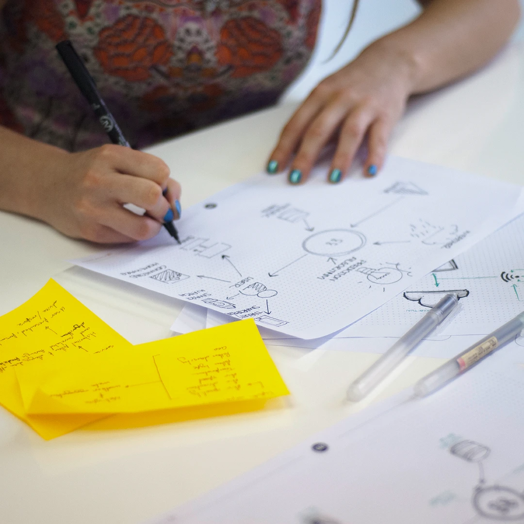 A young woman sketches out concepts and ideas for a digital product