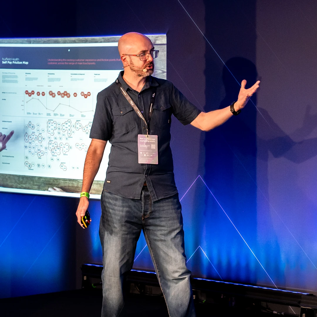 Our Experience Director on stage at a conference discussing Friction Mapping