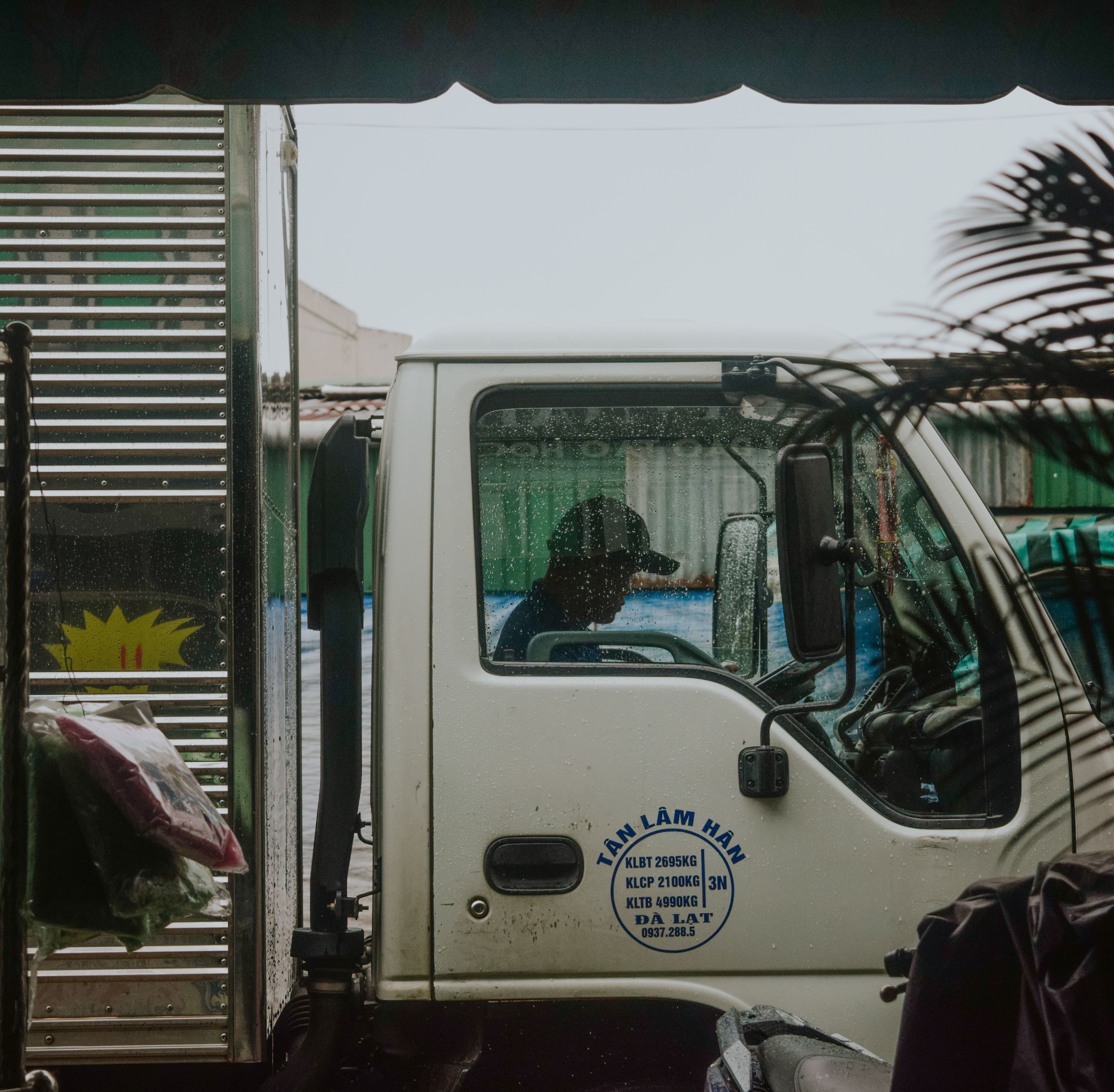 Truck driver sitting in the cab of a lorry on a rainy day