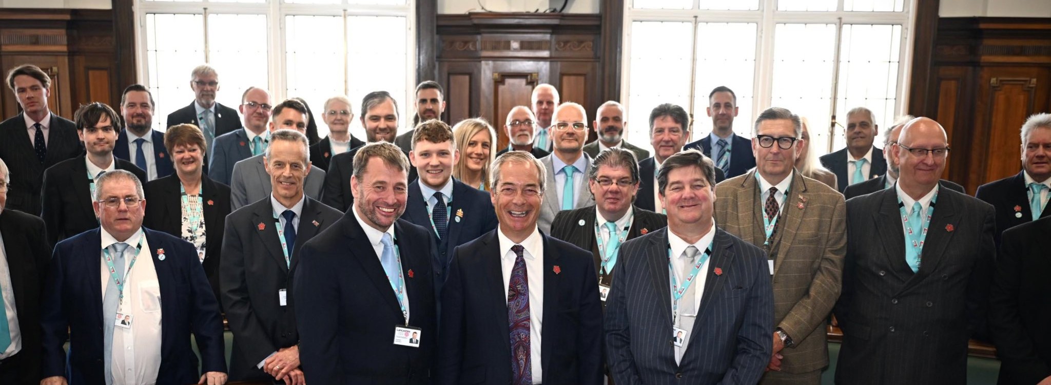 Large group of formally dressed men posing together in an ornate room