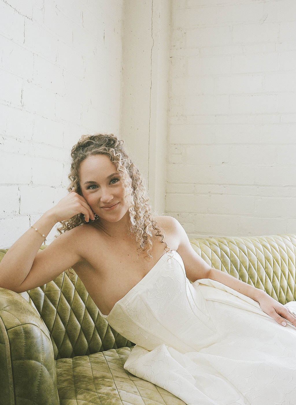 Close-up black-and-white photo of a couple holding hands on a wooden table, with a visible engagement ring on the woman's finger.