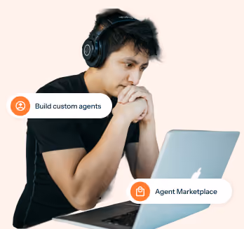 Man with headphones looking at a laptop with tags: Build custom agents, Agent Marketplace.