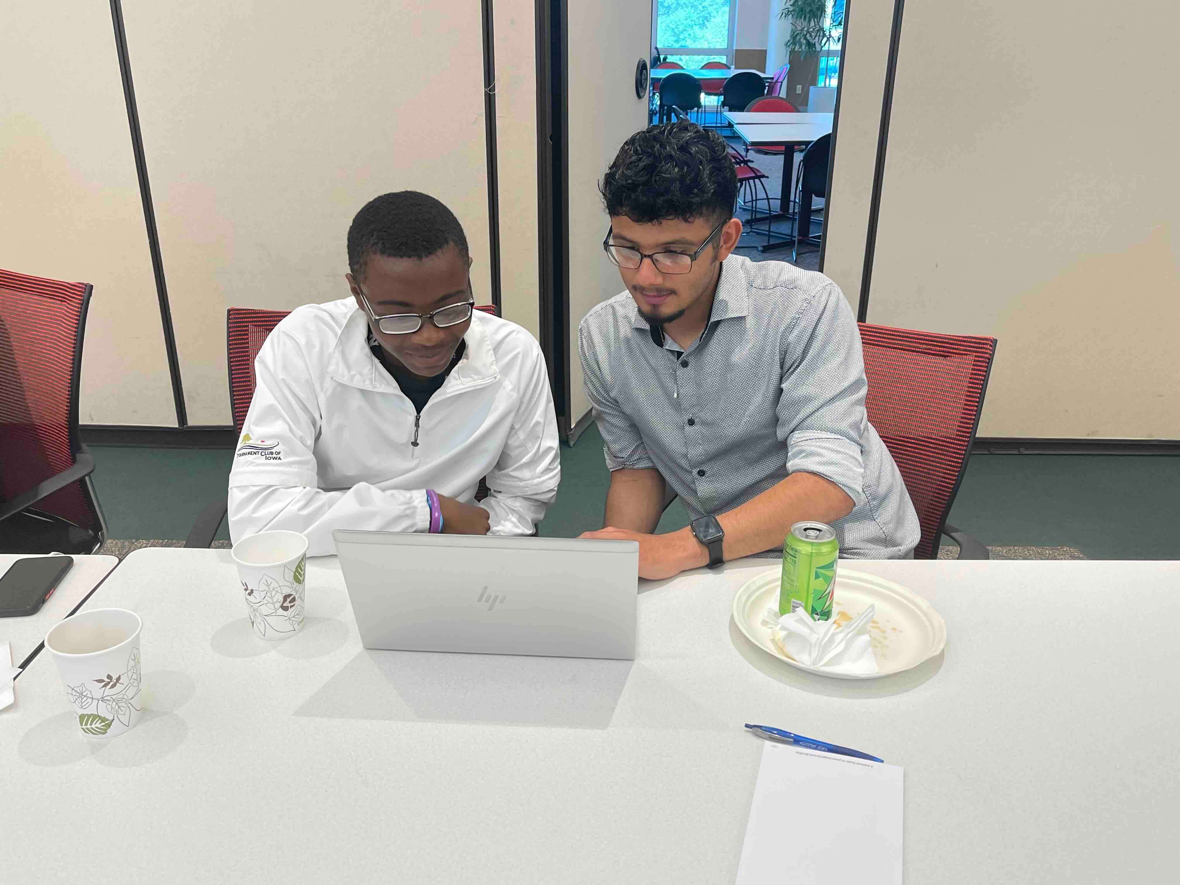 Diverse group of people form a circle, reaching hands towards the center. The tone is collaborative and inclusive, conveying unity and support.