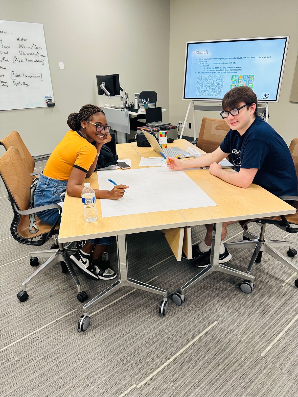 Bustling café scene with diverse patrons engaged in conversations and phone use. Bright, airy space with industrial décor and wooden shelves in the background.